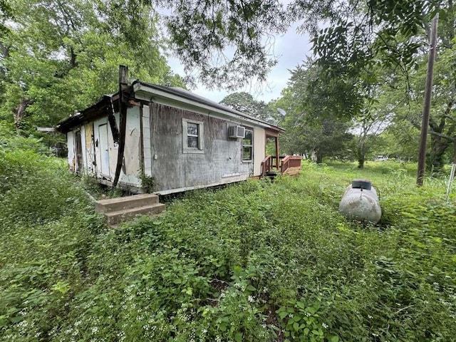 view of side of property with a wall mounted air conditioner