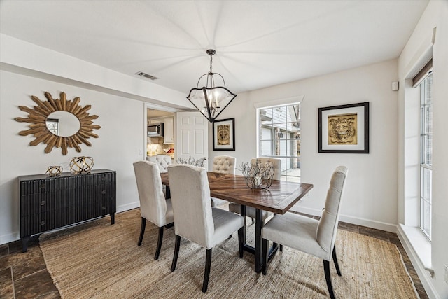 dining room featuring visible vents, baseboards, and a chandelier