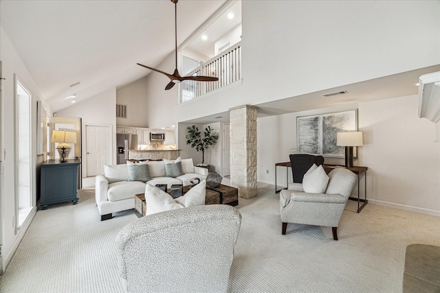 living area featuring a ceiling fan, decorative columns, light colored carpet, and visible vents