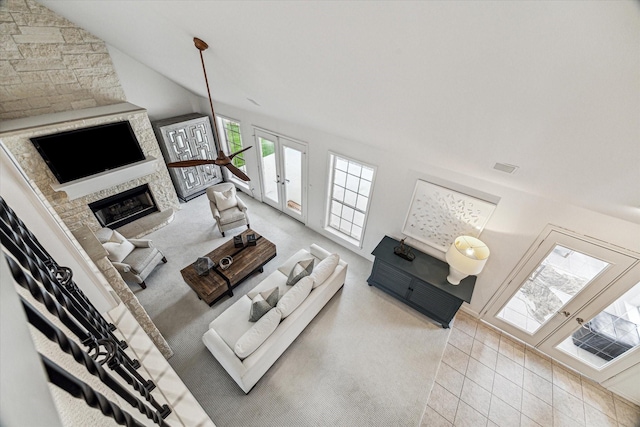 living room with french doors, lofted ceiling, and a fireplace