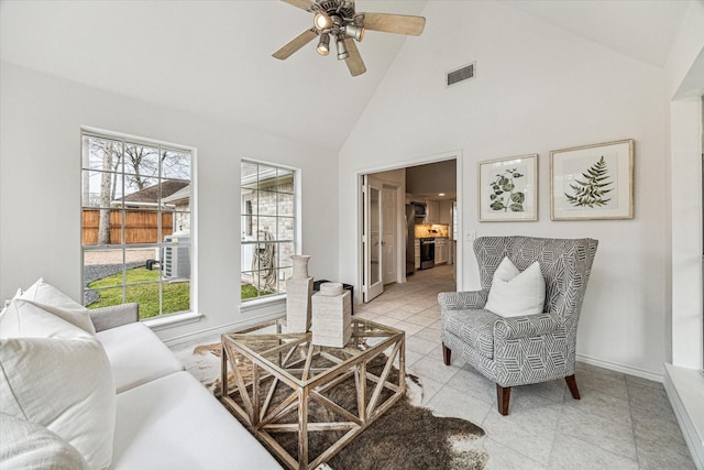 living room featuring light tile patterned flooring, visible vents, a healthy amount of sunlight, and baseboards