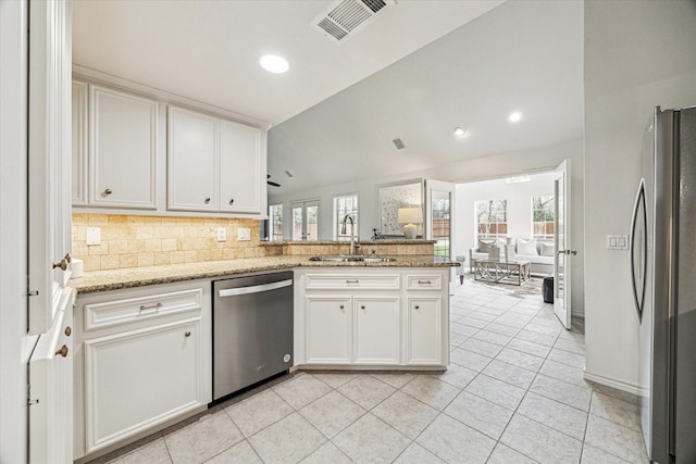 kitchen featuring visible vents, appliances with stainless steel finishes, a peninsula, plenty of natural light, and a sink