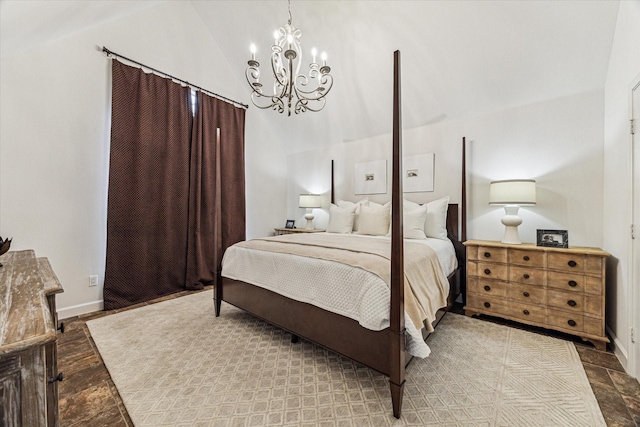 bedroom with vaulted ceiling, baseboards, stone finish floor, and a chandelier