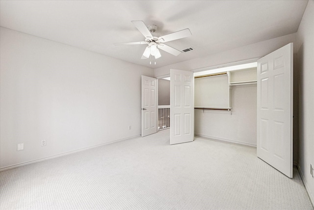 unfurnished bedroom featuring visible vents, baseboards, ceiling fan, a closet, and light carpet