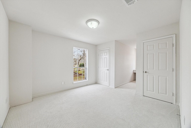 carpeted spare room with visible vents and baseboards