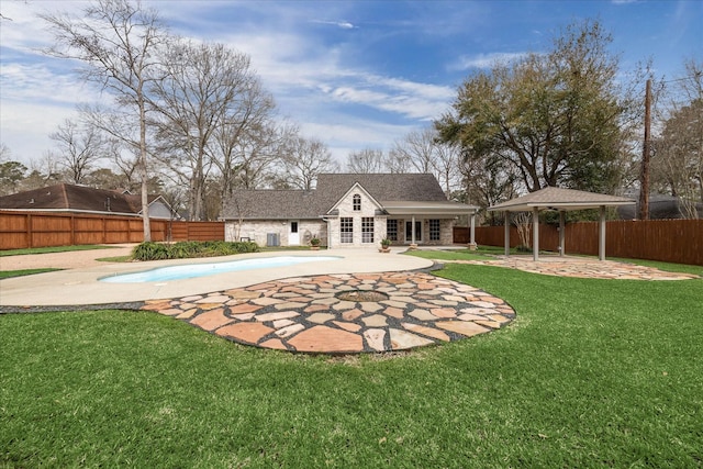 rear view of house featuring a fenced in pool, a gazebo, a lawn, a fenced backyard, and a patio area