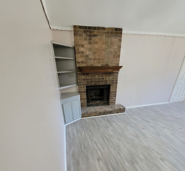 unfurnished living room with a fireplace, wood finished floors, and baseboards