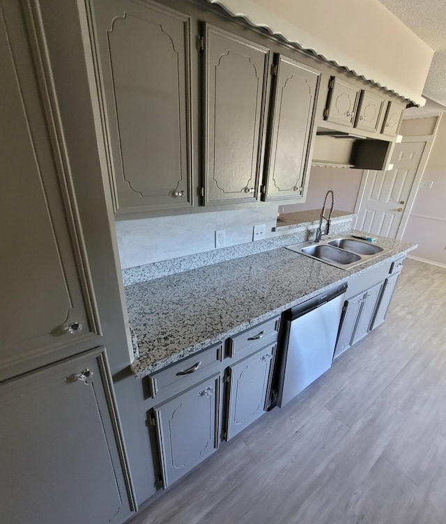 kitchen with light wood finished floors, baseboards, dishwasher, gray cabinets, and a sink