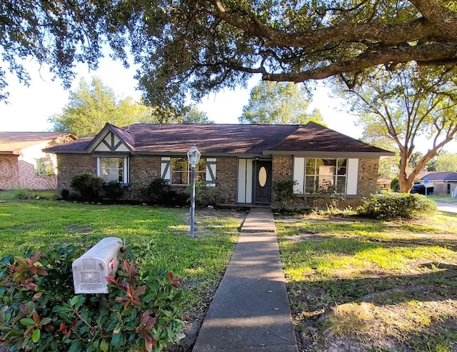 view of front facade featuring brick siding and a front yard