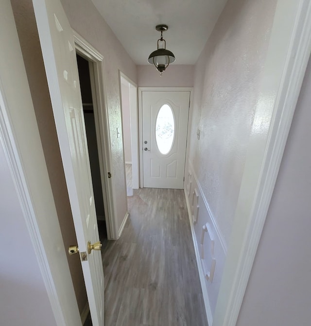 doorway to outside featuring a textured wall and wood finished floors