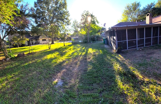 view of yard featuring a sunroom and fence