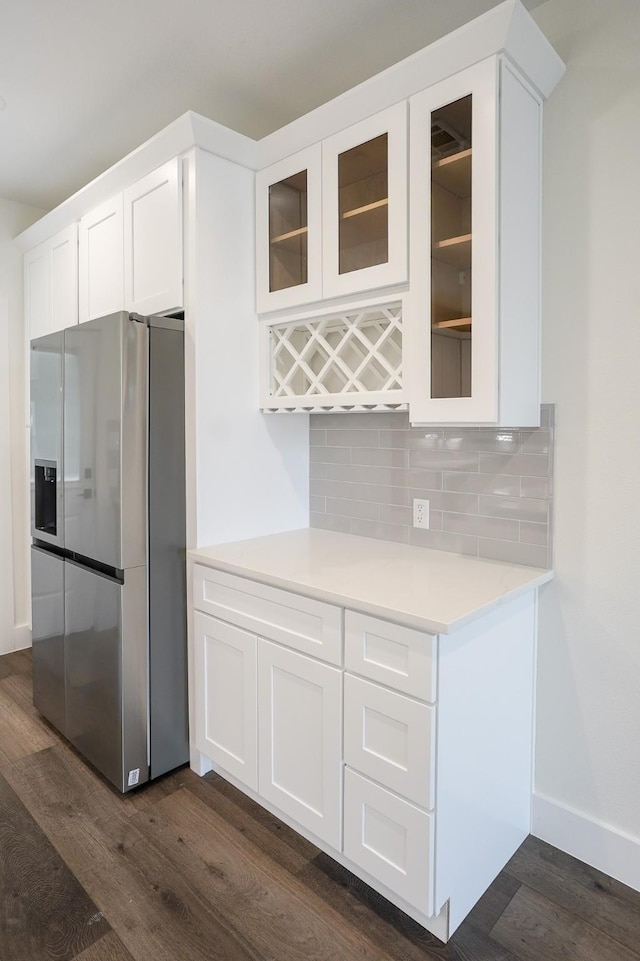 kitchen with dark wood-type flooring, white cabinets, backsplash, and stainless steel fridge with ice dispenser