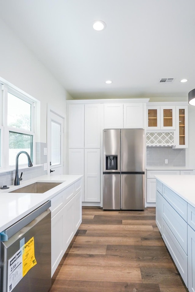 kitchen featuring dark wood-type flooring, a sink, visible vents, white cabinetry, and appliances with stainless steel finishes