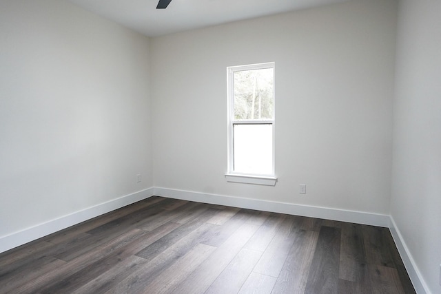 unfurnished room featuring dark wood-style floors, ceiling fan, and baseboards