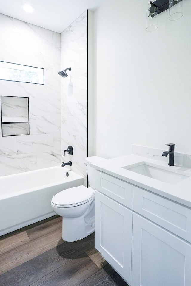 full bath with toilet, bathtub / shower combination, wood finished floors, and vanity