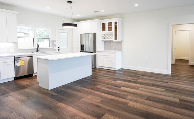 kitchen featuring dark wood-style floors, appliances with stainless steel finishes, decorative backsplash, and a sink