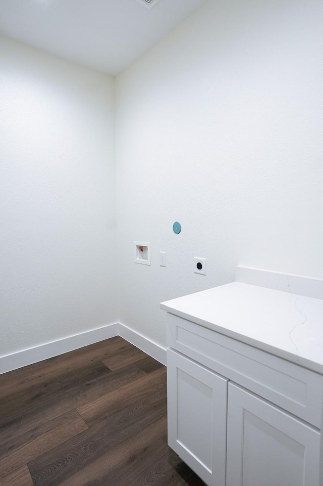 washroom featuring cabinet space, baseboards, dark wood finished floors, washer hookup, and electric dryer hookup