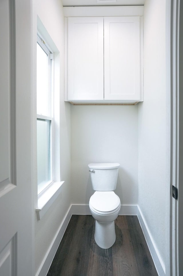 bathroom with toilet, baseboards, and wood finished floors