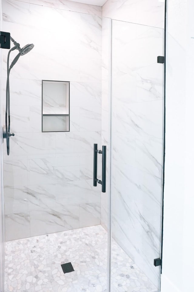 bathroom featuring a marble finish shower