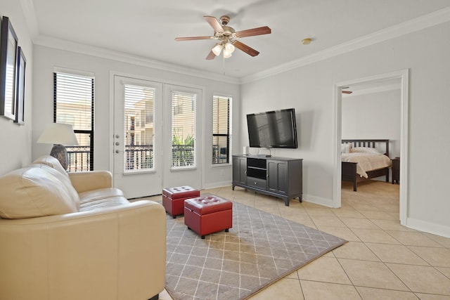 living room with ceiling fan, crown molding, baseboards, and light tile patterned floors