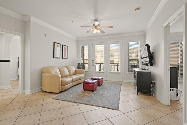 living area featuring ceiling fan, baseboards, crown molding, and light tile patterned flooring