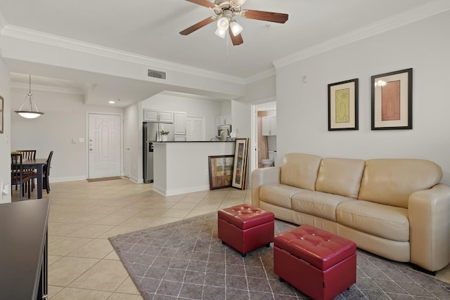 living room with ornamental molding, visible vents, baseboards, and light tile patterned floors