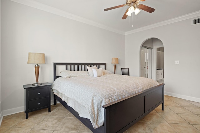 bedroom featuring arched walkways, light tile patterned floors, baseboards, and crown molding