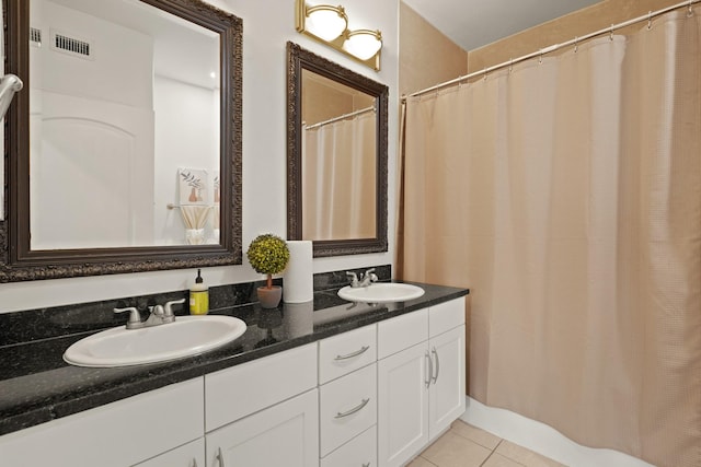 bathroom with double vanity, visible vents, a sink, and tile patterned floors