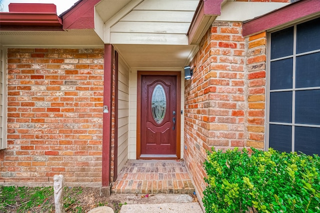 property entrance featuring brick siding