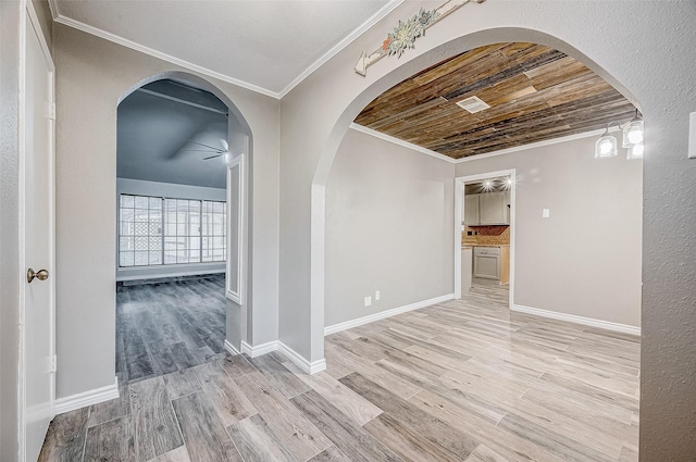 hall with arched walkways, visible vents, ornamental molding, wood finished floors, and baseboards