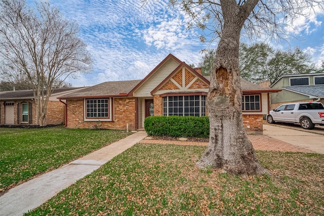 view of front facade with a front yard and brick siding