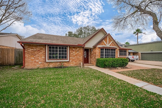 view of front of property featuring driveway, a front yard, fence, and brick siding