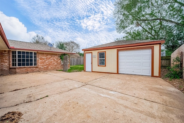 detached garage with driveway and fence