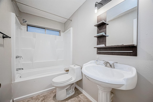 bathroom featuring toilet, baseboards, and tub / shower combination