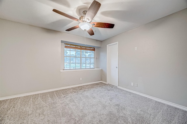 spare room with carpet flooring, a ceiling fan, and baseboards