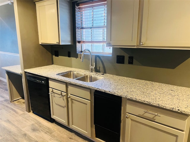 kitchen featuring dishwasher, light stone counters, a sink, and light wood-style floors