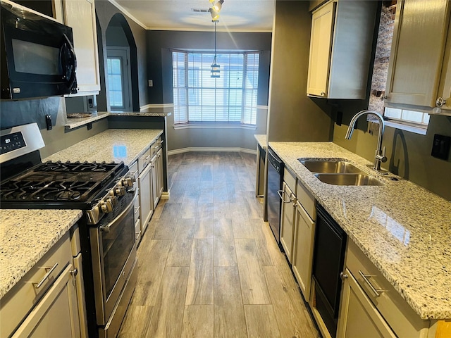 kitchen featuring a sink, baseboards, ornamental molding, black appliances, and light wood finished floors