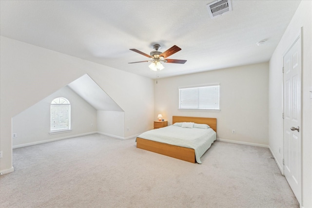 bedroom with baseboards, a ceiling fan, visible vents, and light colored carpet