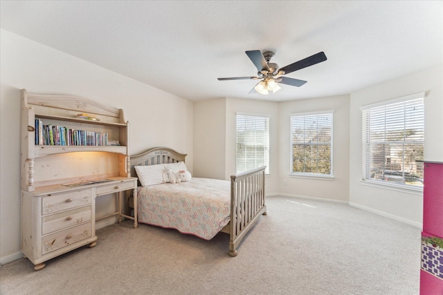 bedroom with light carpet, ceiling fan, and baseboards