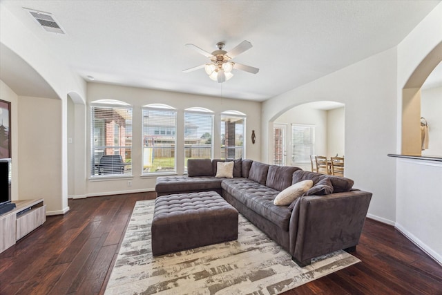 living area featuring baseboards, visible vents, ceiling fan, and hardwood / wood-style floors