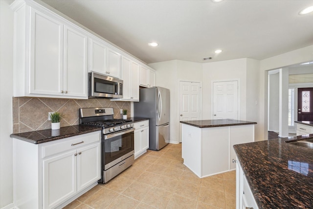 kitchen featuring recessed lighting, stainless steel appliances, visible vents, white cabinetry, and backsplash