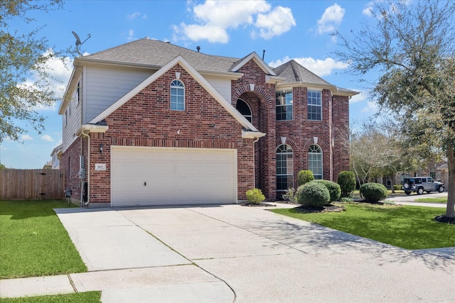 traditional home with a garage, concrete driveway, fence, a front lawn, and brick siding