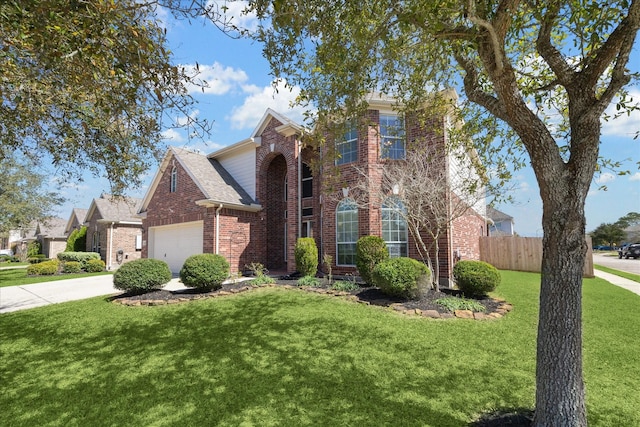 traditional home featuring a garage, concrete driveway, fence, a front lawn, and brick siding