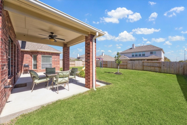 view of yard with a fenced backyard, ceiling fan, and a patio