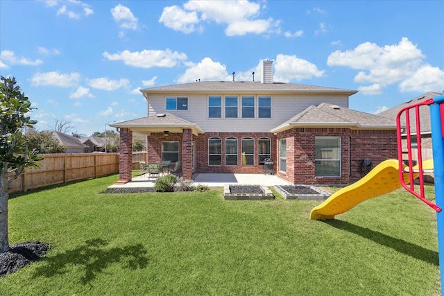 rear view of property featuring brick siding, a yard, a playground, a patio area, and fence