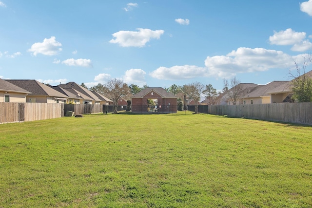 view of yard featuring a fenced backyard and a residential view