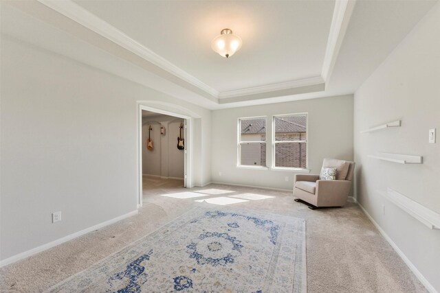 unfurnished room featuring carpet, a raised ceiling, crown molding, and baseboards