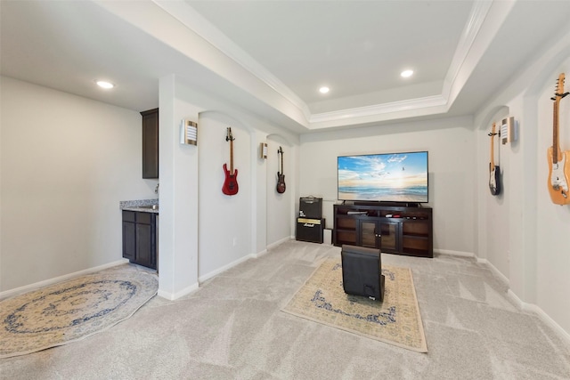 home theater with baseboards, light colored carpet, a tray ceiling, crown molding, and recessed lighting