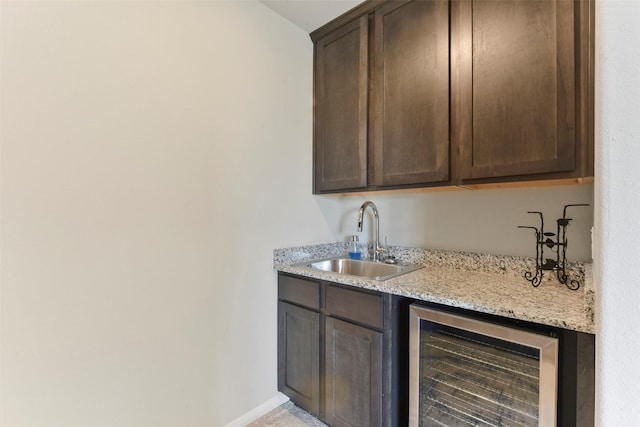 bar featuring wine cooler, a sink, and baseboards