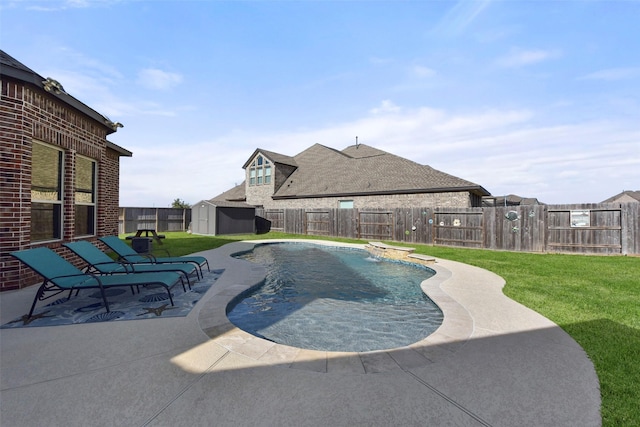 view of swimming pool with a storage shed, a lawn, a fenced backyard, an outbuilding, and a patio area